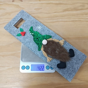 Close-up of a Christmas gnome wine bottle cover on a scale weighing 42.2 grams