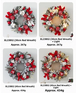 Detail view of snowy Christmas wreath with red bow, pine cones, and festive ornaments