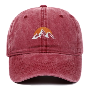 Washed red cotton baseball cap featuring mountain embroidery and vintage sun design