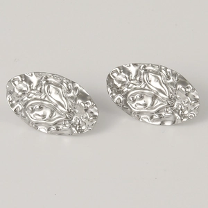 Macro shot of polished silver pleated earrings with irregular lava texture and 304 steel