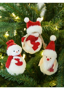 Plush Christmas tree ornaments featuring snowman, Santa and girl hanging on festive tree