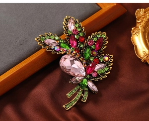 Detail of vintage leaf brooch with pink crystals and rhinestones on brown silk