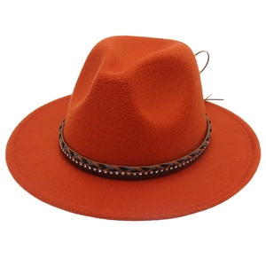 Dettaglio macro del cappello fedora rosso ruggine in lana con nastro intrecciato e strass