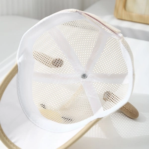 Detail view of breathable white mesh and beige fabric on a toddler summer baseball cap