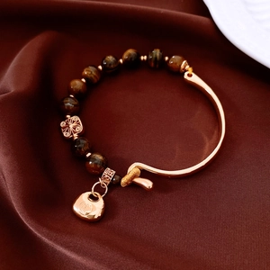 Detail of 18K gold-plated tiger eye beaded bracelet with a vintage lock pendant