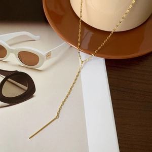 Detailed view of a gold Y-shaped minimalist necklace with a sleek horizontal bar pendant