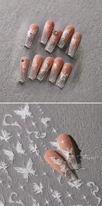 Detail of butterfly embossed nail stickers with orange pink gradient and glitter accents