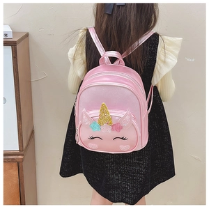 Pink unicorn kids backpack with gold sequins and colorful ears shown on a child model