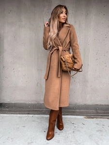 Detail of camel wool coat featuring a classic lapel collar and matching waist belt