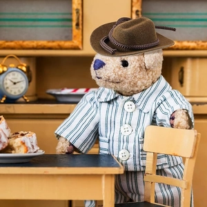 Close-up of mini brown felt cowboy hat with woven rope on a teddy bear doll