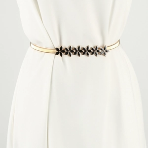 Detail of gold elastic metal waist chain with five black floral decorative buckles