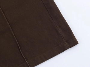 Dettaglio delle cuciture precise e della trama twill sull'orlo del gilet di cotone marrone