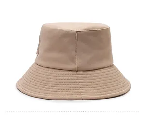 Vue latérale d'un chapeau bob en toile beige avec bord renforcé et écusson décoratif