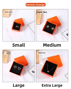 Macro detail of orange jewelry gift boxes with assorted rings and earrings on display