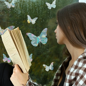 Close-up of holographic butterfly window decals with rainbow prism reflections