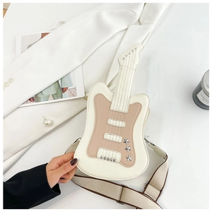 Detail view of guitar shaped bag with silver star studs and wide khaki fabric shoulder strap