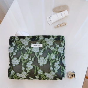 Close-up of floral mesh cosmetic bag with green embroidery and simple wish label
