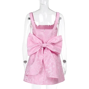 Détail du dos d'une robe rose en jacquard avec un grand nœud décoratif et fermeture éclair