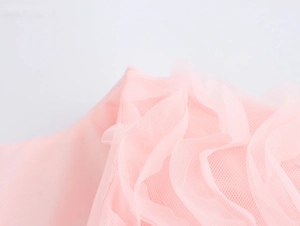 Vue macro de la texture du tissu en tulle rose pour les hauts et les chemisiers en dentelle