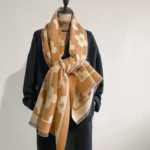 Thick floral pattern knit scarf with fringe displayed on a mannequin in beige and brown