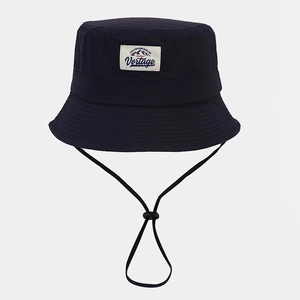 Close-up of adjustable windproof drawstring and ball buckle on a navy bucket hat