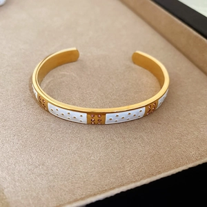 Détail du motif d'étoile dorée sur bracelet émaillé blanc avec des zircons roses