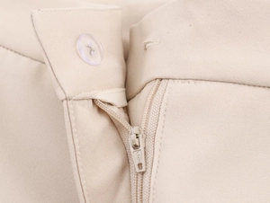Detail der beige Anzughose mit einem Metallreißverschluss und einem einzelnen Knopfverschluss