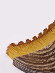 Macro detail of crescent foundation brush with wavy bristles and textured handle