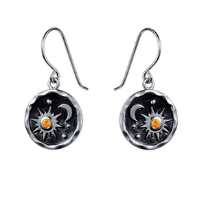 Macro shot of bohemian sun and moon drop earrings with amber gemstones and silver finish