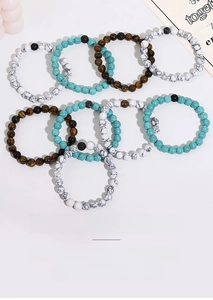 Flat lay of beaded bracelets with turquoise, tiger eye, and lava stones in vintage style