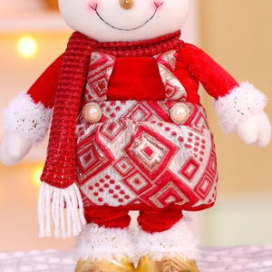 Détail d'un bonhomme de neige en peluche avec écharpe rouge et salopette à losanges