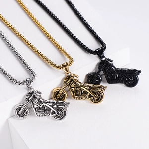 Three hip hop motorcycle pendants in silver, gold, and black on a white tiered display stand