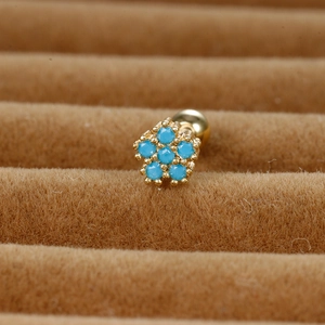 Minimalist gold flower stud earring with blue zircon gemstones on brown velvet