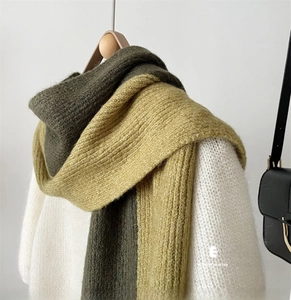 Detail of color-block knit scarf in olive green and mustard yellow with thick texture