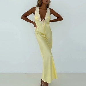 Détail d'une robe en satin jaune avec bordure en dentelle blanche et décolleté en V