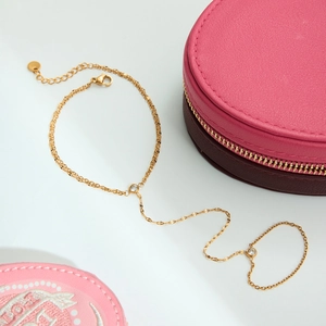 Detail of 18k gold plated slave bracelet with cubic zirconia stones on silk background