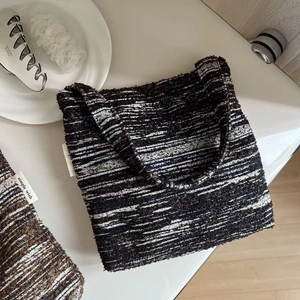 Detail of tweed woven handbag with simple wish label and matching accessories