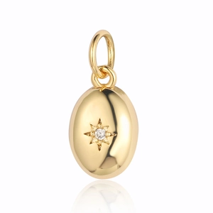 Detailed view of a golden oval pendant featuring a star pattern and central zircon stone