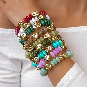 Detail of layered bohemian acrylic beaded bracelet with irregular golden metal beads