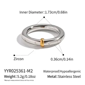 Vue détaillée de la bague en acier inoxydable avec zircons et un petit charme doré rond