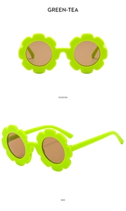 Detailed view of green flower-shaped children's sunglasses with brown round lenses