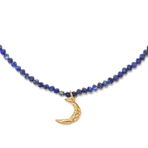 Detail of beaded necklace with blue lapis lazuli stones and golden crescent moon pendant