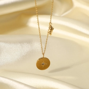 Detail view of 18K gold plated necklace with starburst engraved round pendant on satin