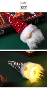 Close-up of glowing LED Christmas gnome ornament with red sequins and white fur beard
