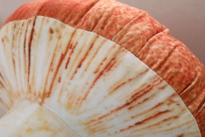 Macro detail of plush mushroom pillow showing stitching and realistic gill textures