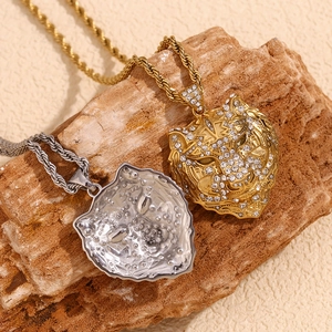Close-up of gold and silver tiger pendants with crystals on a textured rope chain