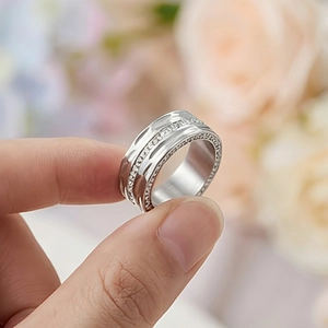 Macro shot of silver-tone stainless steel wide band ring set with sparkling zircon pavé