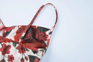 Detail of floral spaghetti strap top with red rose print and adjustable buckle