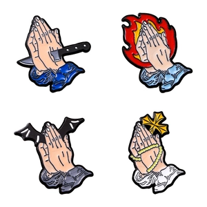 Cartoon enamel pins set featuring praying hands with daggers, bats, and crosses for clothes