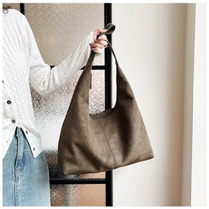 Detail of a brown matte suede tote bag showing large capacity and textured stitching
